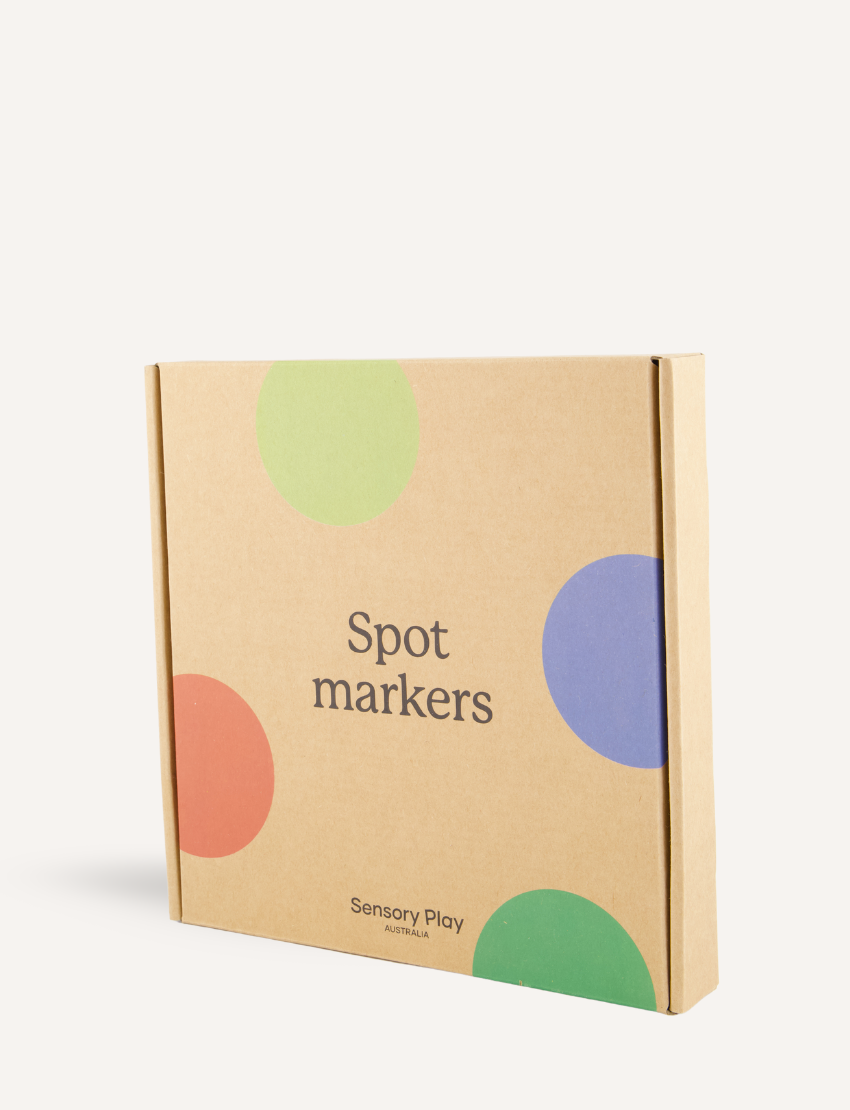 A box labeled "Spot Markers" from Sensory Play Australia features large colored dots in green, blue, red, and purple to boost gross motor skills and fitness.