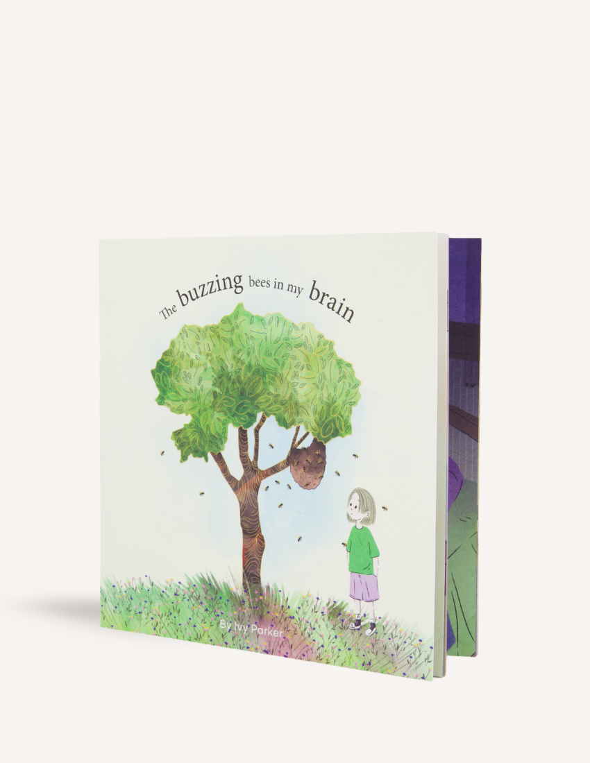 Cover of "The Buzzing Bees in My Brain Storybook" by Ivy Parker, a publication from The Play Way. The illustration features a girl standing near a tree with a beehive, encircled by bees. She is depicted wearing a green shirt, purple pants, and red shoes, embodying the sense of being overwhelmed amidst the buzzing chaos. This storybook is ideal for providing tips to parents on handling meltdowns.