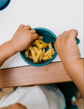 The Sensory Friendly Food Handling Kit by The Play Way comes in a cardboard box containing an assortment of kitchen utensils, ideal for enhancing fine motor skills. It includes peelers, fruit sticks, and a versatile kitchen tool, all neatly displayed in open brown boxes with a green and blue patterned box beneath.