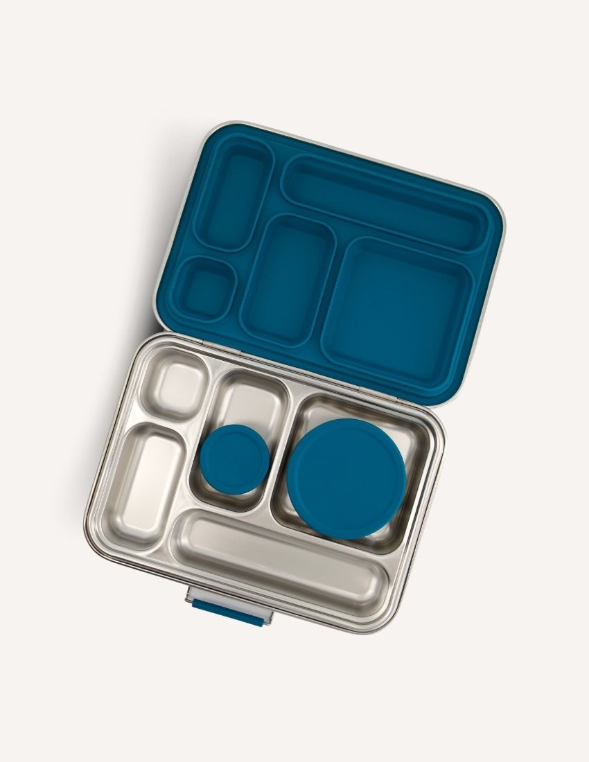 Introducing the Lunch Buddy Bento Set by The Play Way, a sleek rectangular stainless steel lunchbox with multiple compartments. The top right section is larger than the others, with "TPW" engraved in the central compartment. It features a silicone seal lid, rounded edge design, clasp closure, and a polished metallic finish.