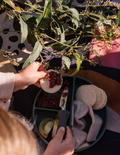 The Sensory Friendly Food Handling Kit by The Play Way comes in a cardboard box containing an assortment of kitchen utensils, ideal for enhancing fine motor skills. It includes peelers, fruit sticks, and a versatile kitchen tool, all neatly displayed in open brown boxes with a green and blue patterned box beneath.