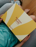 Lifestyle image of a child holding the yellow box of the Routines Buddy Magnetic Planner Set on their lap. A toolkit from Sensory Play Australia designed to empower children and families with daily routines.