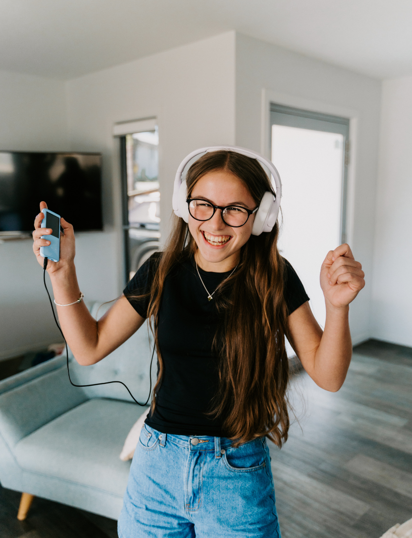 The Regulation and Reflection Kit by The Play Way contains various educational and sensory items. Visible items include a book titled "STIMS, SCHOOL & ME," breathing cards, a mini MP3 player, reflective journal cards, a sensory play kit, and a book titled "The Buzzing Busy Brain.