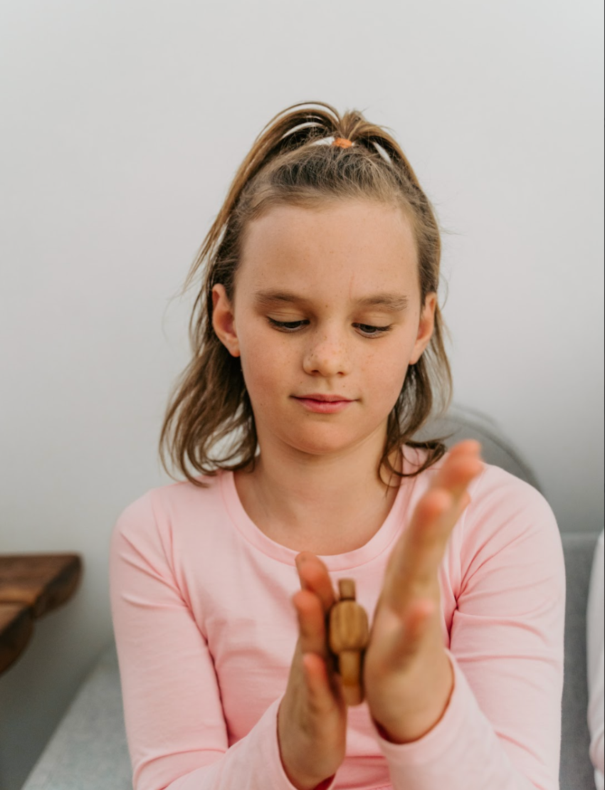 The Regulation and Reflection Kit by The Play Way contains various educational and sensory items. Visible items include a book titled "STIMS, SCHOOL & ME," breathing cards, a mini MP3 player, reflective journal cards, a sensory play kit, and a book titled "The Buzzing Busy Brain.