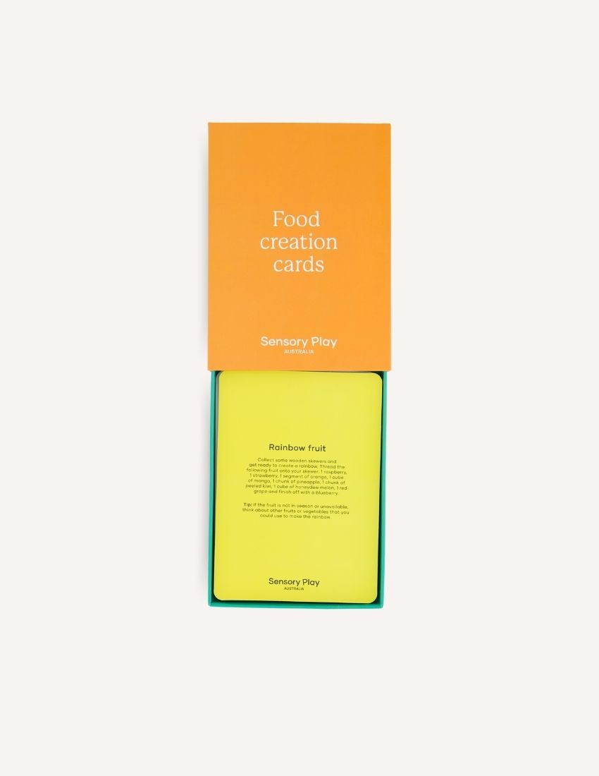 The image displays two orange items titled "Food Creation Cards Set in Box" by Sensory Play Australia. The smaller box is positioned on the left with its lid closed, while the larger box stands upright on the right. Both items, ideal for culinary creativity, are set against a plain white background.