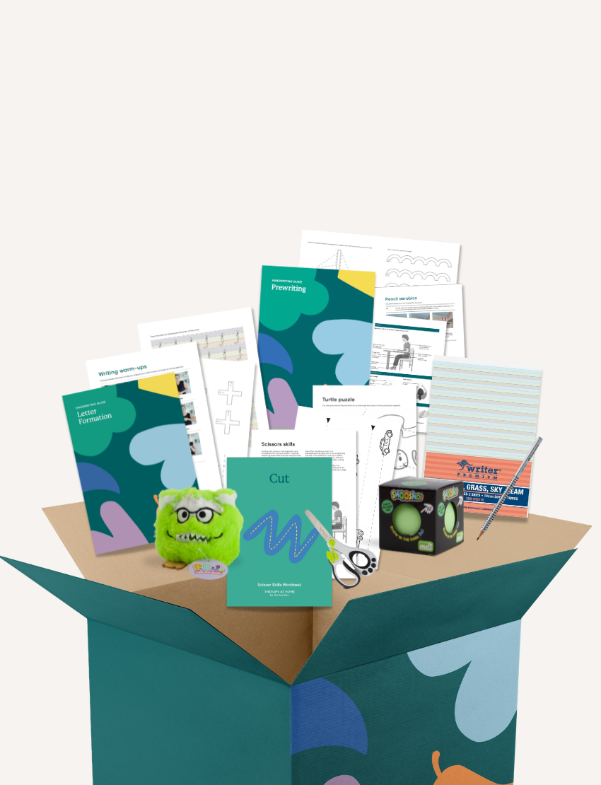 Discover the "Getting Started with Writing Kit" by The Play Way, an open teal box filled with educational materials for budding writers, including worksheets, a black dice with colorful dots, scissors, a green plush toy adorned with eyes and a mouth, and essential writing tools like a pencil and eraser.