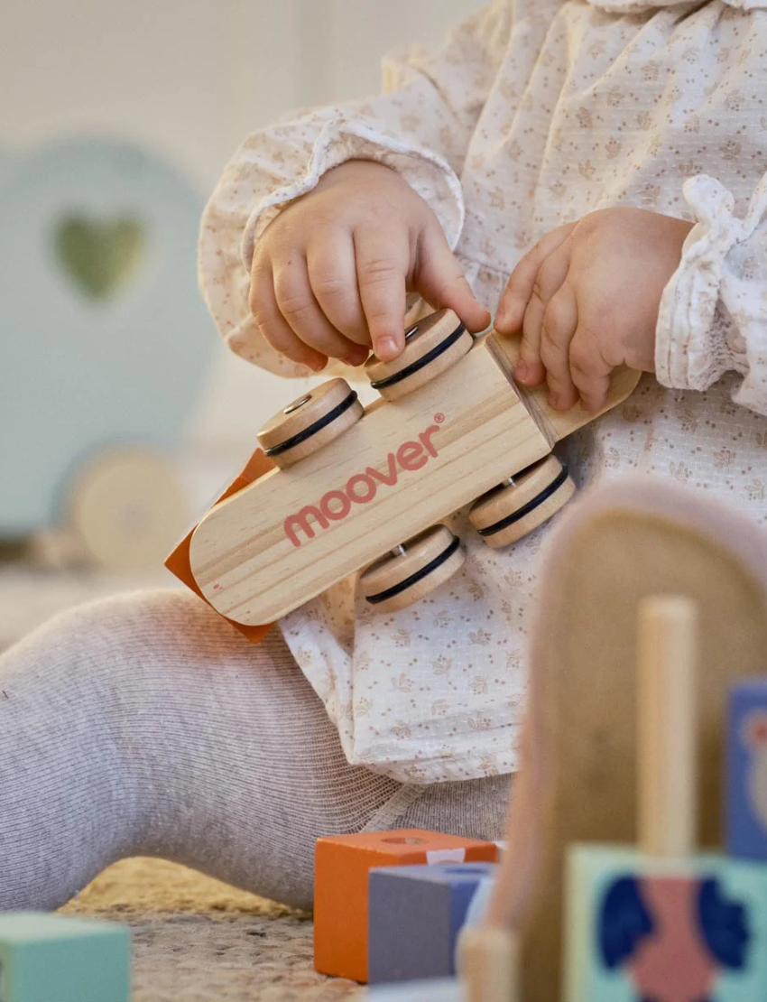 The Moover Block Train features four carriages with colorful block animals—a cartoon fox, raccoon, bunny, bear, and bird. Made with non-toxic paints on a natural wooden base with wheels, it's perfect for enhancing young children's motor skills.