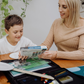The Creative Mindfulness: Mandalas Program by The Play Way includes a vibrant open box with markers, colored pencils, notebooks, paint, a tote bag, and crafting materials. It has abstract green, purple, and orange patterns with "The Play Way" text.