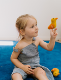 The Early Years Language Program by Therapy At Home features an open teal box neatly filled with educational toys, animal figurines, wooden blocks, a toy tea set, illustrated cards, books, and activity sheets for play-based learning and language development.
