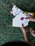The Early Years Language Program by Therapy At Home features an open teal box neatly filled with educational toys, animal figurines, wooden blocks, a toy tea set, illustrated cards, books, and activity sheets for play-based learning and language development.