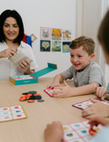 The Therapy At Home Emotions Part 1: Naming our Feelings Program comes in a teal and green box with colorful shapes, containing books, cards, charts, and activities to help children build emotional awareness and understand feelings.