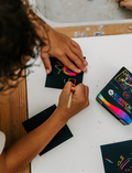 The Therapy At Home Fine Motor Advanced Program features a vibrant box with modeling clay, a 3D paper model kit, cards, stickers, markers, and more—ideal for building fine motor skills as recommended by occupational therapists.