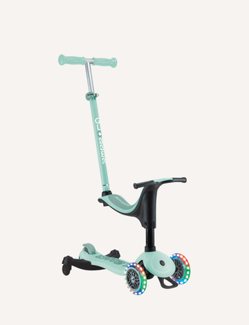 The Go Up Sporty Lights 360 is a mint green children's scooter by Globber, featuring a detachable seat and three wheels. The front wheels are equipped with colorful LED lights, and the handlebar is adjustable.