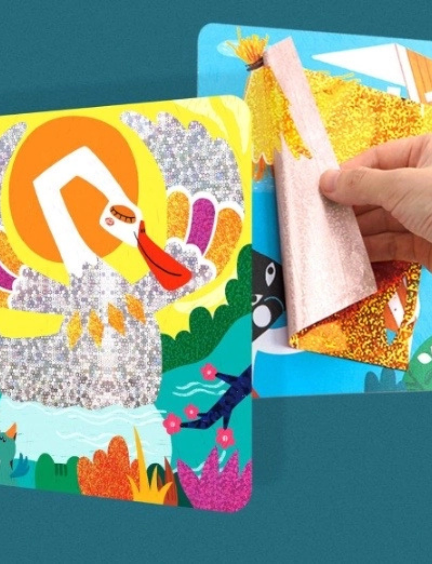 A close-up of a hand peeling back a sparkly, translucent layer from the vibrant Flash Stickers - The Ugly Duckling by Jar Melo. The artwork features abstract shapes and characters in dominant shades of orange, red, and yellow, with a shimmering texture overlay.