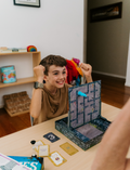 An open Therapy At Home Language Promotion Program box with playful green and teal designs reveals educational books, cards, and colorful language development activity materials neatly arranged inside.