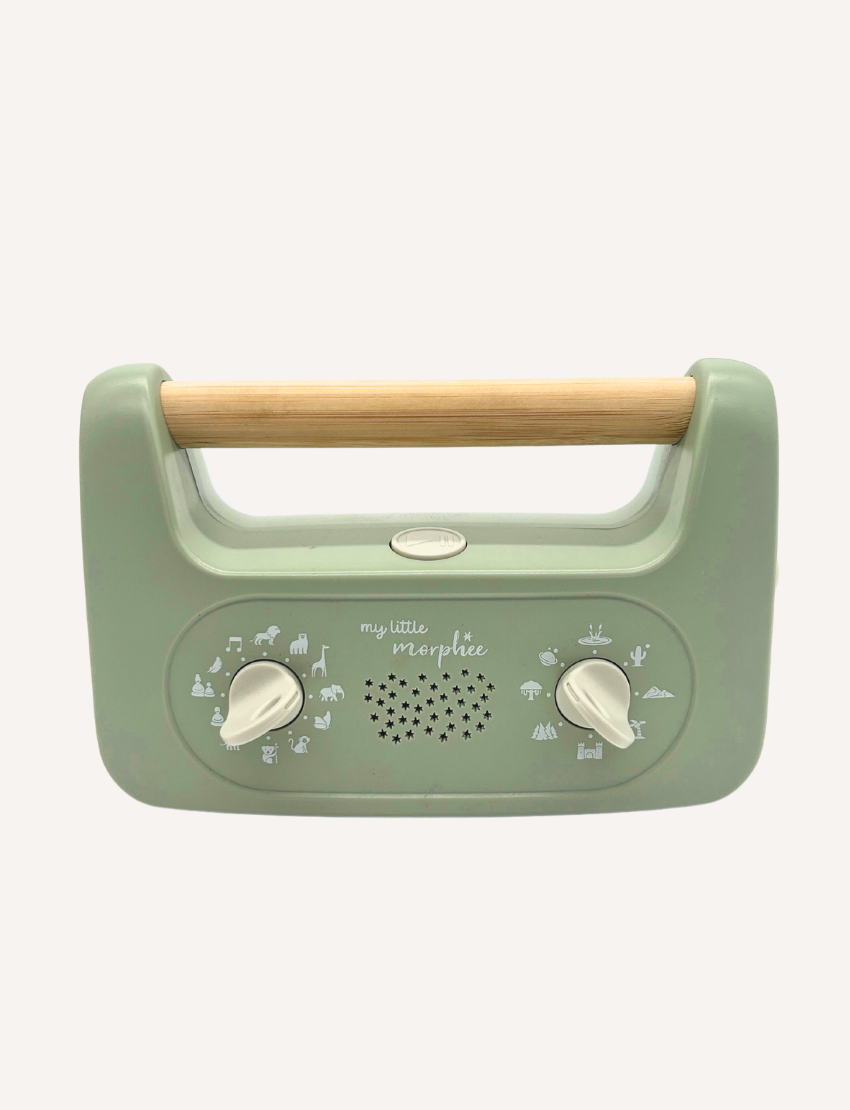 Sporting a soft green design and a wooden handle, the My Little Morphee Relaxation & Sleep Aid by Morphee features two dials and a speaker grille. The front showcases white illustrations along with the brand name "my little morphée," providing calming sounds for restful sleep.