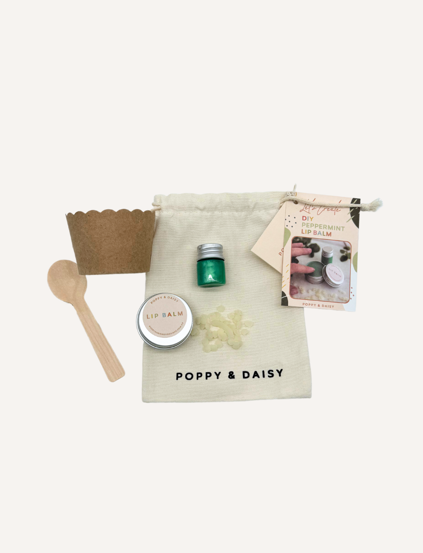 Poppy & Daisy DIY Peppermint Lip Balm kit: bag, balm tin, green liquid, wooden spoon, and cup.