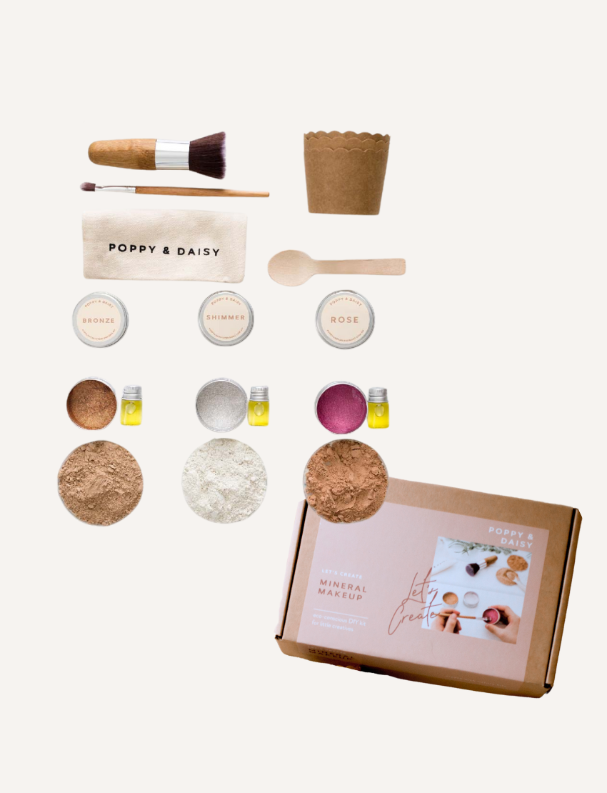 Poppy & Daisy 'Mineral Makeup' DIY kit laid out: powders, oils, brush, wooden spoon, paper cups, and box.