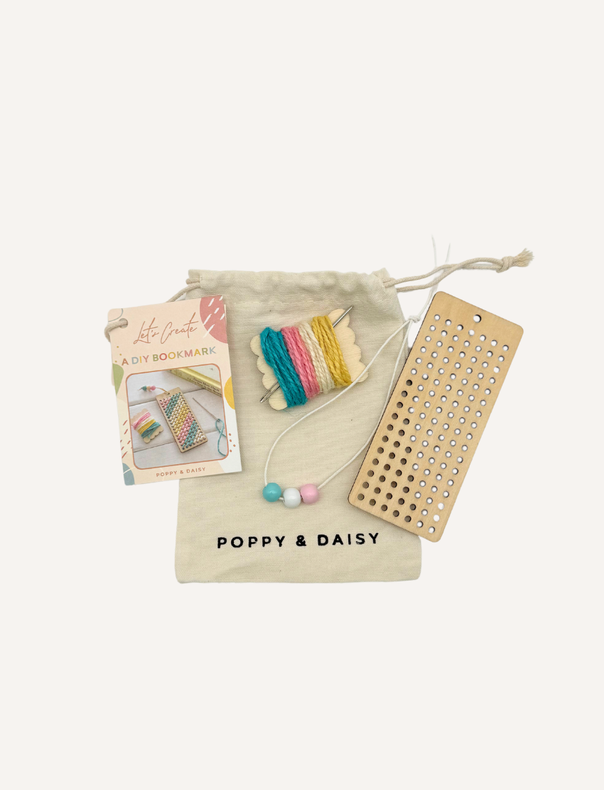 Poppy & Daisy DIY bookmark kit contents: pouch, wooden board, yarn, beads, and craft instructions.
