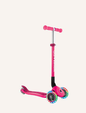 The Globber PRIMO Foldable Lights Scooter is a pink three-wheeled scooter with LED wheels that sparkle while gliding. It features an adjustable T-bar with metal handlebars, pink grips, and a stability-enhancing footboard.