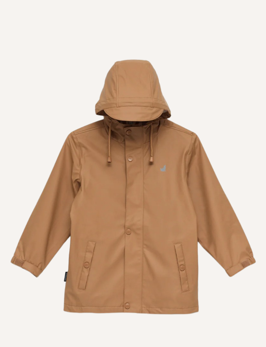 The Cry Wolf Play Jacket in tan is a waterproof hooded raincoat made from eco-friendly, recycled materials. It features a buttoned and zippered front, two flap-front pockets, elastic-cuffed long sleeves for comfort, and a small chest logo.