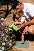 The EverEarth Outdoor Gardening Bag With Tools is a green set ideal for children's outdoor play, featuring a watering can, spade, trowel, and small fork with wooden handles. These tools are neatly displayed in front of a canvas tote decorated with green polka dots and multiple pockets.