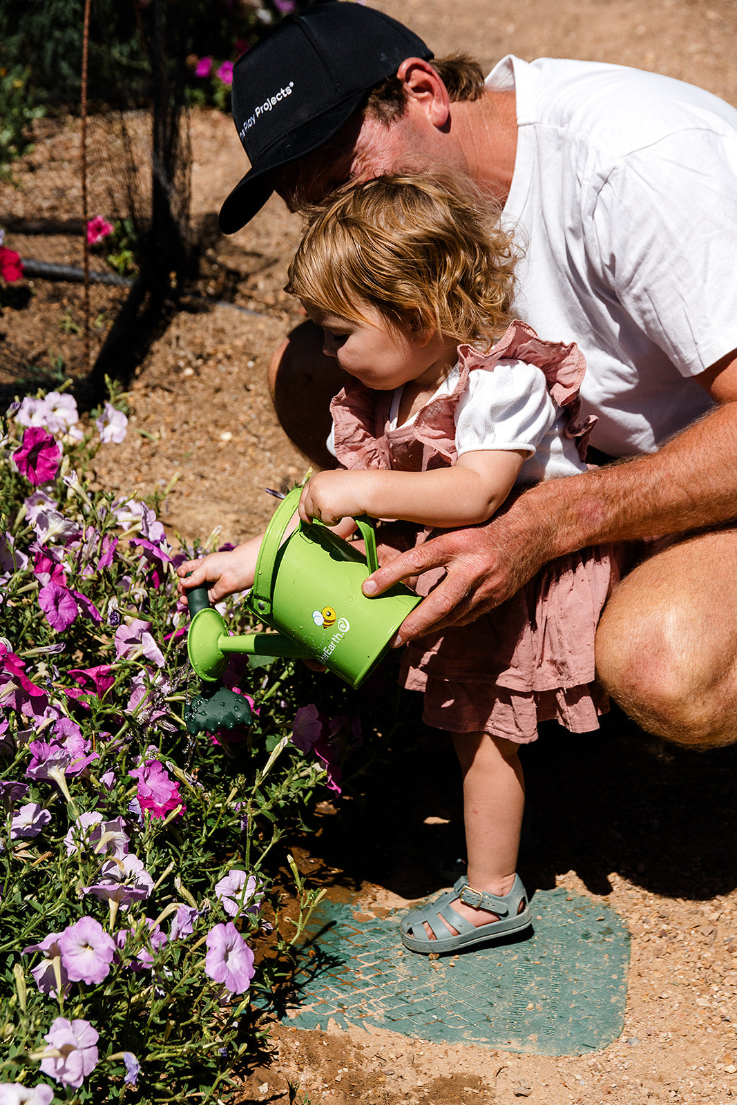 The EverEarth Outdoor Gardening Bag With Tools is a green set ideal for children's outdoor play, featuring a watering can, spade, trowel, and small fork with wooden handles. These tools are neatly displayed in front of a canvas tote decorated with green polka dots and multiple pockets.