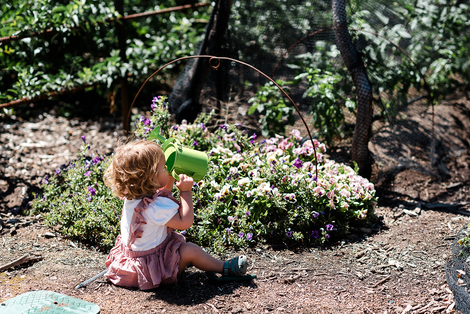 The EverEarth Outdoor Gardening Bag With Tools is a green set ideal for children's outdoor play, featuring a watering can, spade, trowel, and small fork with wooden handles. These tools are neatly displayed in front of a canvas tote decorated with green polka dots and multiple pockets.