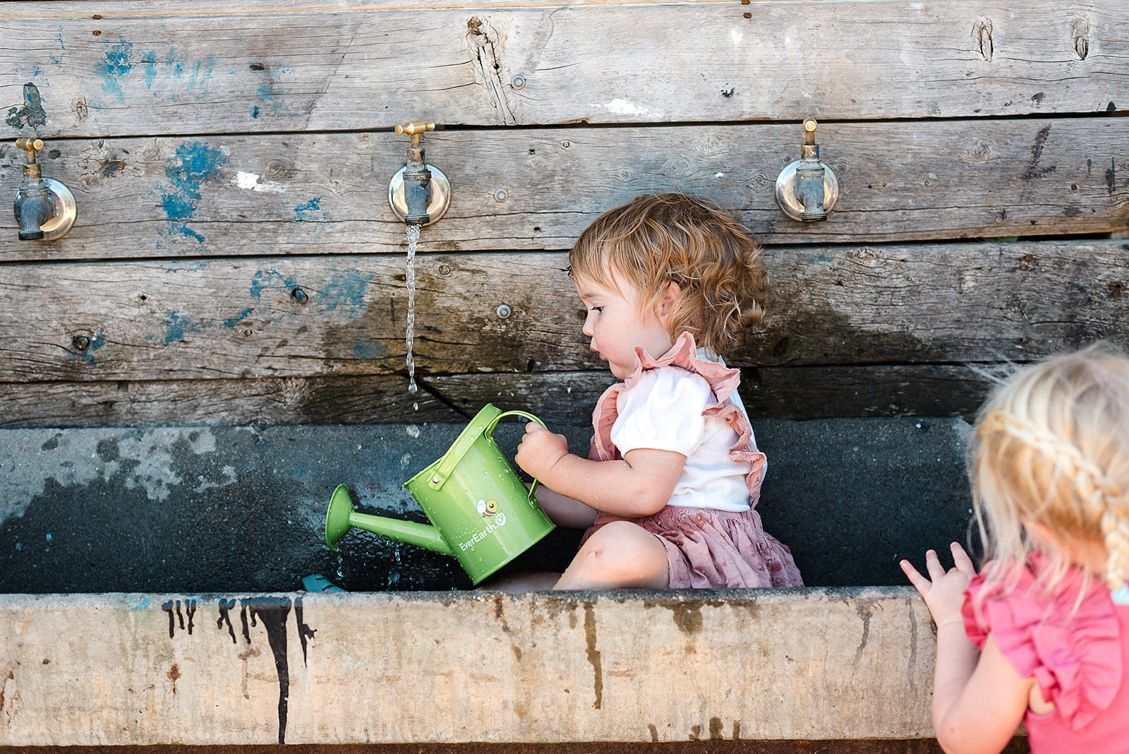 The EverEarth Outdoor Gardening Bag With Tools is a green set ideal for children's outdoor play, featuring a watering can, spade, trowel, and small fork with wooden handles. These tools are neatly displayed in front of a canvas tote decorated with green polka dots and multiple pockets.