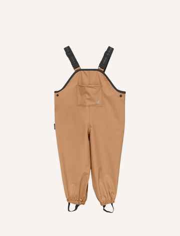 A pair of children's tan waterproof Rain Overalls from Cry Wolf with elasticated ankle cuffs, black adjustable shoulder straps, and the words "Cry Wolf" printed in gray on the back. There are black foot straps at the bottom of each leg opening.