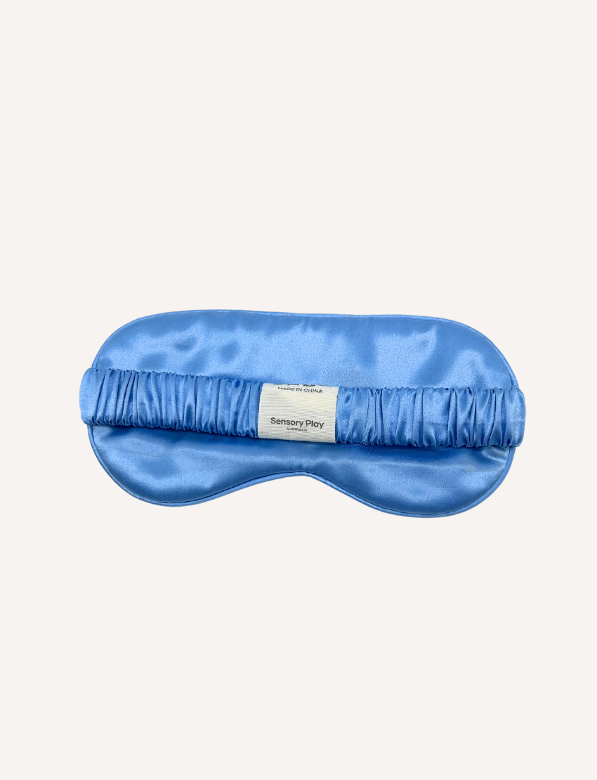 A folded silk pillowcase from Sensory Play Australia is shown next to a matching sleep mask. Both items from the Silk Pillowcase and Eye Mask Set are placed on a white background.