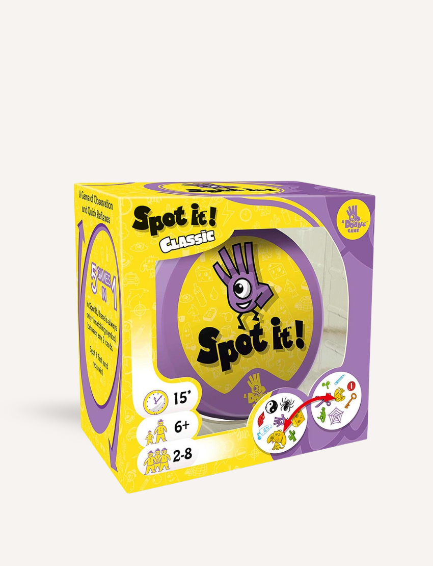 The image features the boxed game "Spot It!" from Jedko Games. The box is decorated in purple and yellow with lively graphics, indicating it's appropriate for 2-8 players, ages 6 and up, with a playing time of 15 minutes.