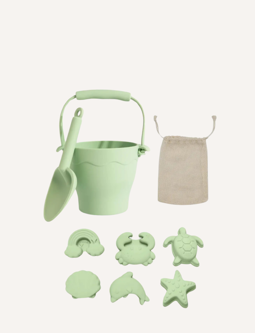 The Playground 8-Piece Bucket & Spade Set features a BPA-free silicone brown bucket, spade, five animal molds (cloud, rainbow, crab, shell, turtle), and a starfish mold. A white drawstring bag is included for easy storage—perfect for sandcastle crafting!.