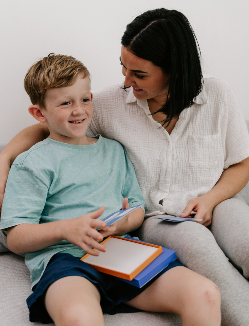 Woman and child interacting with learning cards, fostering connection.