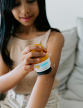 The Therapy At Home Self-Care Program features an open teal gift box filled with lotions, a striped bag, skincare essentials, cards, a hairbrush, and more—perfectly arranged for your self-care routine.