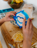 The Lunch Box Program by Therapy At Home comes in a teal and blue patterned box with stainless steel containers, a blue cup, activity cards, planners, a game, and labels—all neatly packed and partially displayed.