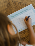 The Lunch Box Program by Therapy At Home comes in a teal and blue patterned box with stainless steel containers, a blue cup, activity cards, planners, a game, and labels—all neatly packed and partially displayed.