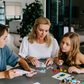 An open blue and green box from Therapy At Home's Build it with Bricks Foundation Program includes two LEGO Classic sets and colorful activity cards—ideal for supporting executive function skills in therapy sessions—displayed on a plain light background.