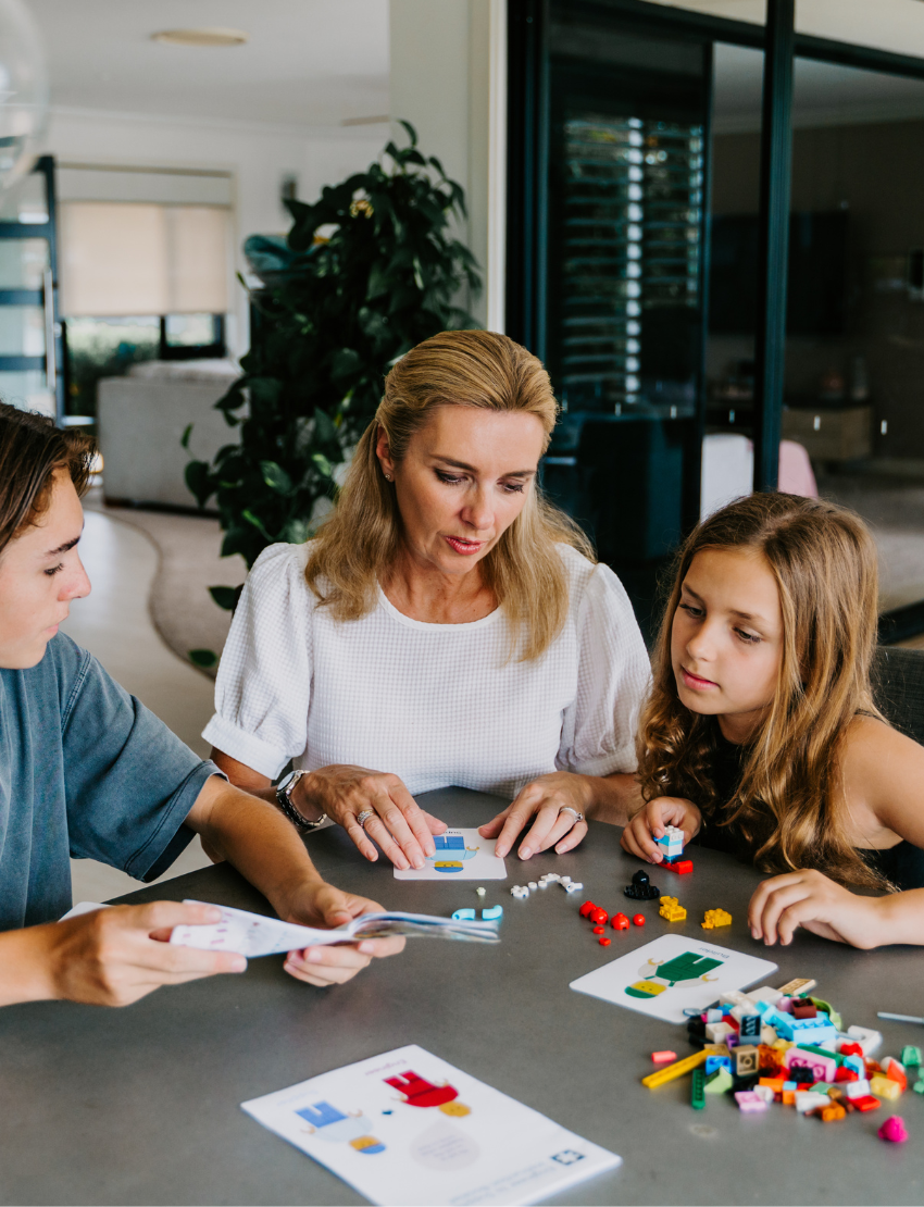 An open blue and green box from Therapy At Home's Build it with Bricks Foundation Program includes two LEGO Classic sets and colorful activity cards—ideal for supporting executive function skills in therapy sessions—displayed on a plain light background.
