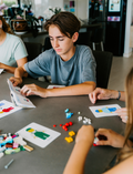 An open blue and green box from Therapy At Home's Build it with Bricks Foundation Program includes two LEGO Classic sets and colorful activity cards—ideal for supporting executive function skills in therapy sessions—displayed on a plain light background.