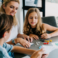 An open blue and green box from Therapy At Home's Build it with Bricks Foundation Program includes two LEGO Classic sets and colorful activity cards—ideal for supporting executive function skills in therapy sessions—displayed on a plain light background.
