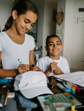 The Express Yourself Program by Therapy At Home features a teal and purple box with paint, markers, brushes, worksheets, bead kit, colored paper, a white cap, and a paint palette—perfect for occupational therapy activities.