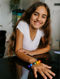 The Express Yourself Program by Therapy At Home features a teal and purple box with paint, markers, brushes, worksheets, bead kit, colored paper, a white cap, and a paint palette—perfect for occupational therapy activities.