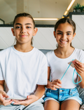 The Express Yourself Program by Therapy At Home features a teal and purple box with paint, markers, brushes, worksheets, bead kit, colored paper, a white cap, and a paint palette—perfect for occupational therapy activities.