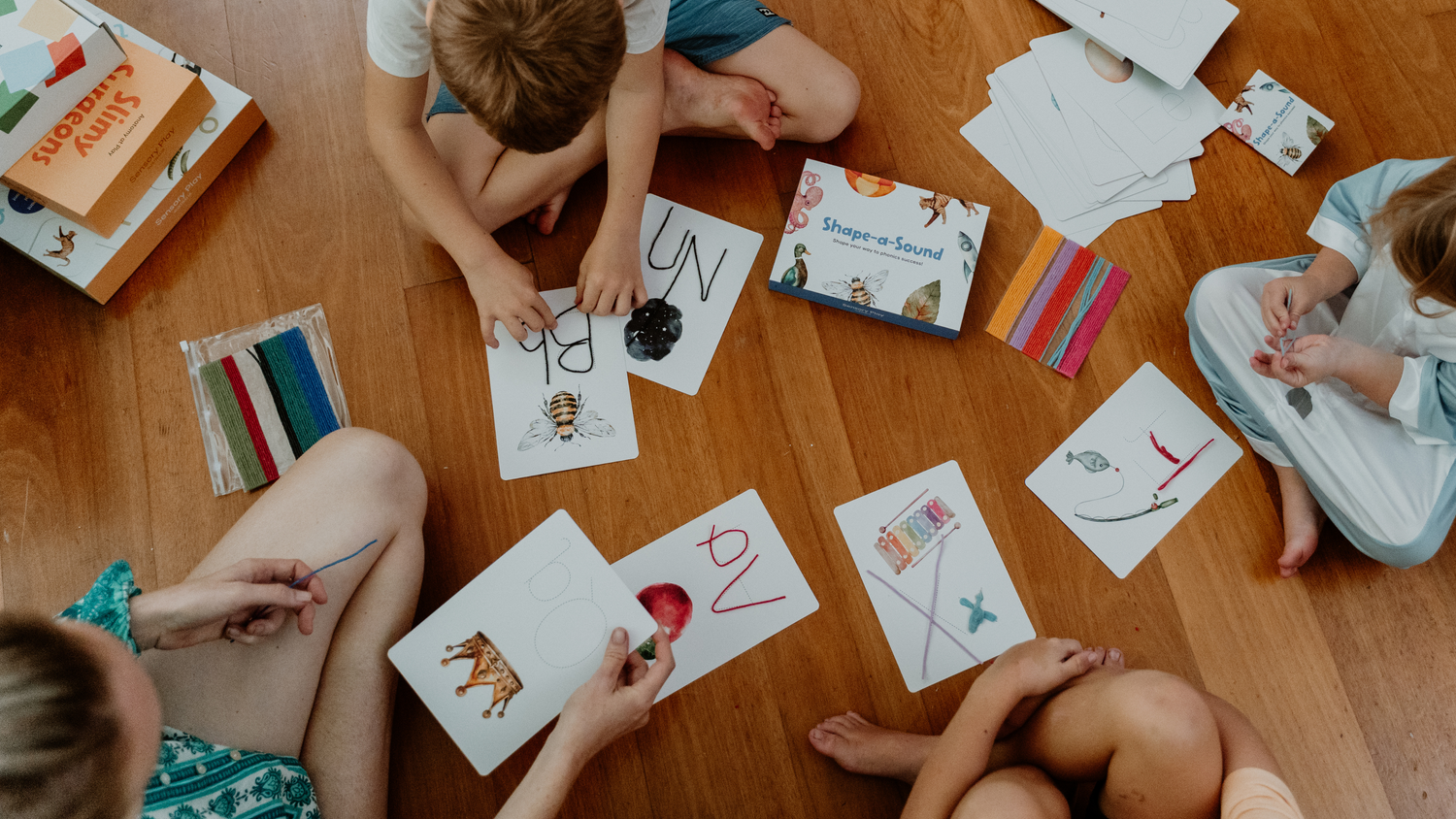Children playing with flashcards on a wooden floor